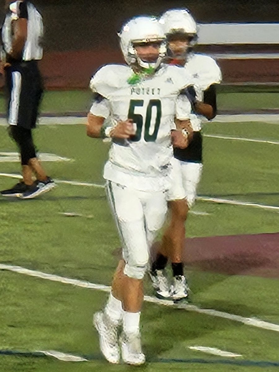 Daylen Shain, number 50, jogging onto the field in a white Poteet football jersey